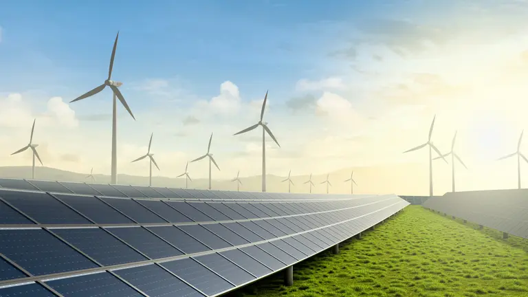 Solar farm and wind turbine on green fields with beautiful sunset background.