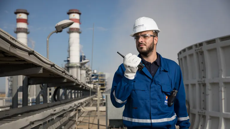 A male OMV Petrom worker at the Brazi Power Plant talking on a walkie talkie
