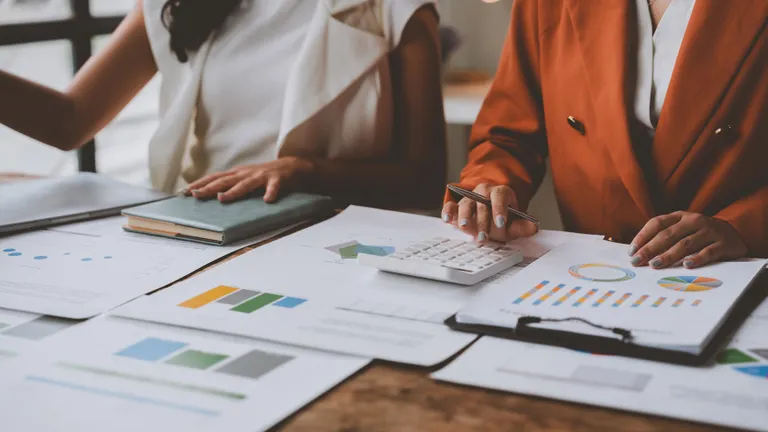 A team of male and female businessmen work together to inspect sales documents. Marketing analysis, action plans, shareholder information. Discuss financial analysis, sales management concepts.